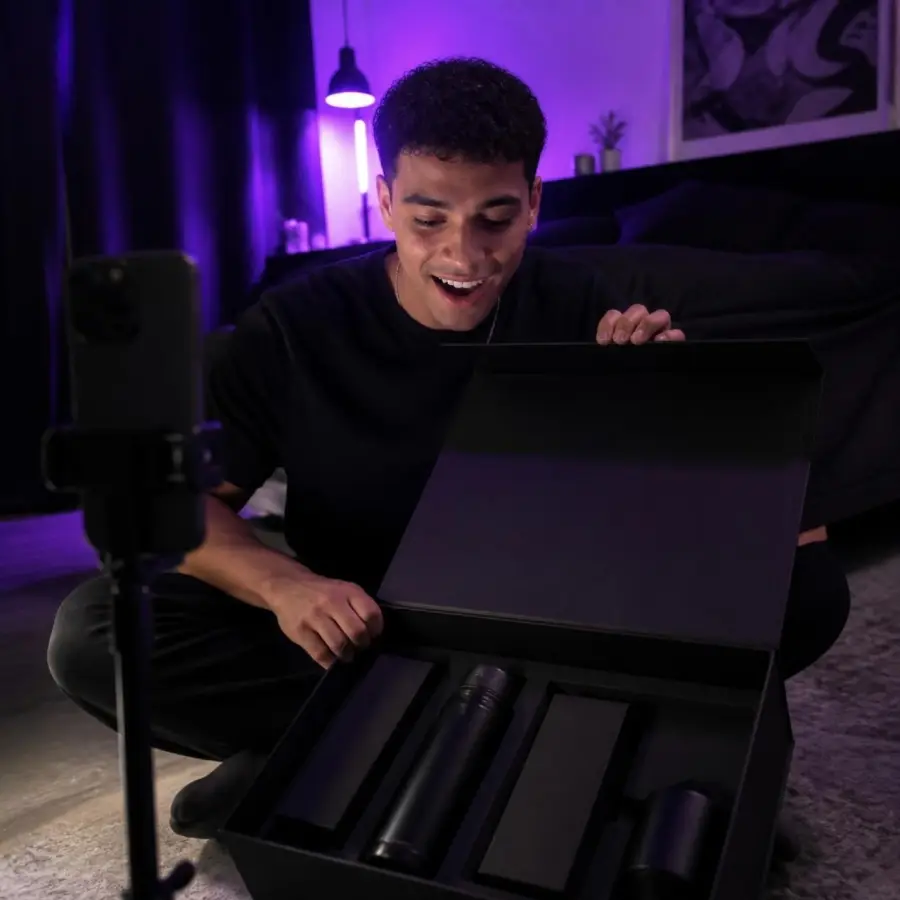 Criador abrindo o kit de produtos da marca