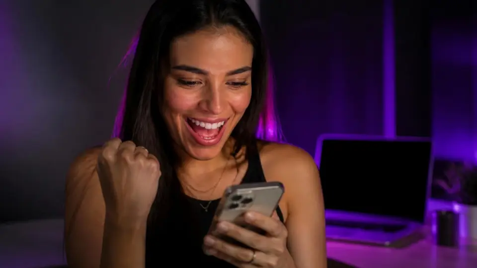 Criadora comemorando uma venda no celular